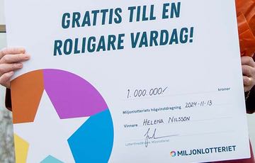 Någon håller i en vinstcheck från Miljonlotteriet på 1 000 000 kr.